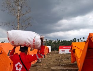 Mukhlas, relawan PMI SULTRA sedang membantu Warga Langkaan, Aceh Utara