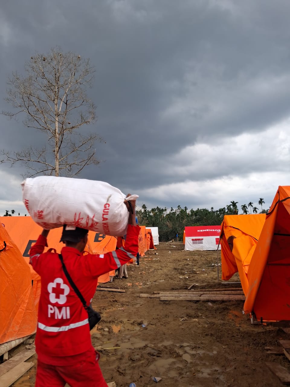 Mukhlas, relawan PMI SULTRA sedang membantu Warga Langkaan, Aceh Utara