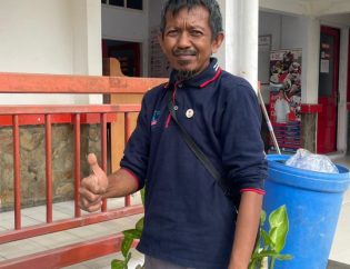 Pak Bela sedang melaksanakan kegiatannya di pagi hari sebelum apel pagi berlangsung.